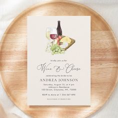 a wine and cheese brunch party is set on a wooden platter with white linens