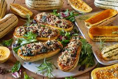 several delicacy dishes are arranged on a table with pumpkins and squash in the background