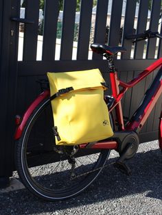 a red bike with a yellow bag on the back