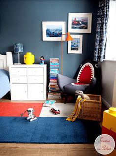 a bedroom with blue walls and red rugs on the floor next to a bed