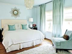 a bedroom with blue walls and white bedding