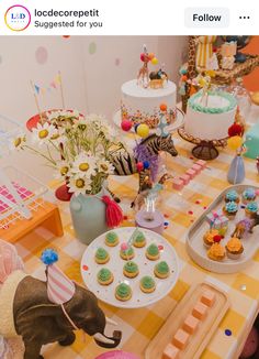 a table topped with cakes and cupcakes next to an elephant figurine