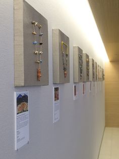 several pieces of jewelry are hanging on the wall next to each other in a hallway