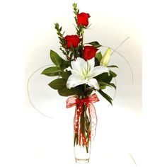 a vase filled with red roses and white lilies