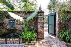 an outdoor area with brick walls and plants on either side of the entrance to the house