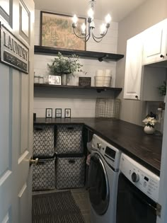 a washer and dryer in a small room with open shelving on the wall