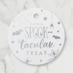 a white and gray halloween ornament with bats, spider webs, and stars