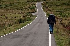 a person walking down the middle of an empty road