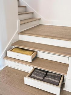 an open drawer under some stairs in a house