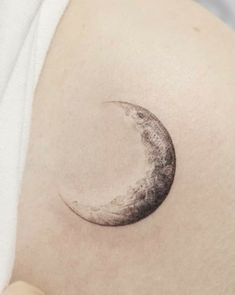 a crescent moon tattoo on the right shoulder