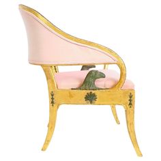 a pink and gold chair with a green turtle on it's back in front of a white background