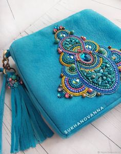 a blue purse with beads and tassels on it