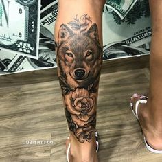 a woman's leg with a wolf and roses tattoo on it