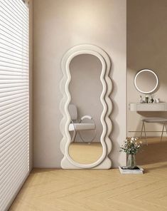 a large white mirror sitting on the side of a wall next to a table and chair