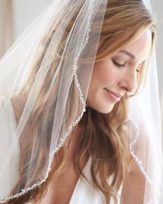 a woman wearing a veil with pearls on it