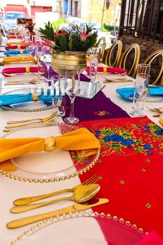 the table is set with place settings and colorful napkins