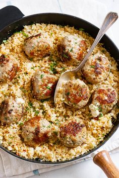 meatballs and rice in a skillet with a serving spoon on the side, ready to be eaten