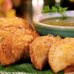 some fried food on a green plate with a bowl of soup in the back ground