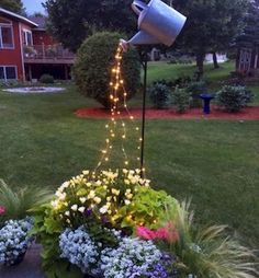 a potted planter filled with flowers and lite up lights in front of a house