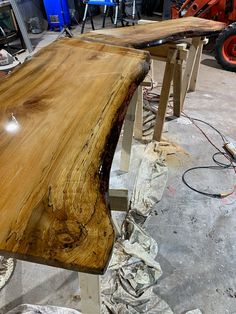 a large wooden table sitting inside of a room next to other woodworking tools and equipment