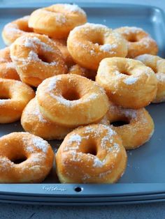 powdered sugar covered donuts on a tray