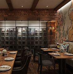 an empty restaurant with wooden tables and black leather chairs in front of a large mural