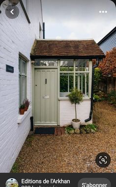 a small white building with a green door