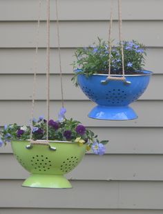 two blue and green hanging planters with flowers in them