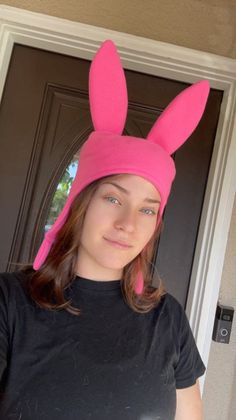 a woman wearing a pink bunny ears hat