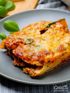 lasagna casserole on a plate with basil leaves