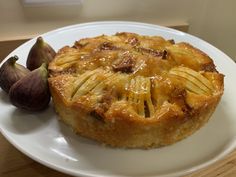 a pastry on a white plate next to an fig