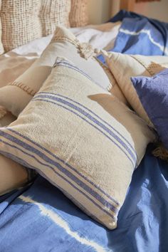 pillows and blankets on a bed with blue sheets