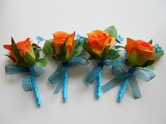 three orange roses with blue ribbons tied to them on a white surface, in the shape of bows