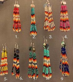 several pairs of colorful earrings hanging from hooks on a wall with numbers in front of them