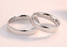 two white gold wedding rings sitting side by side