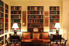 a living room filled with lots of furniture and bookshelves covered in bookcases