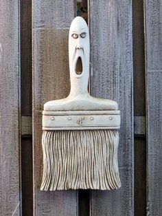 a close up of a mop head on a wooden fence with it's mouth open