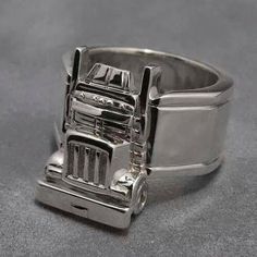 a close up of a silver ring with a truck on it