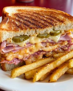 a sandwich and french fries on a white plate