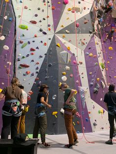 several people are climbing up the side of a wall