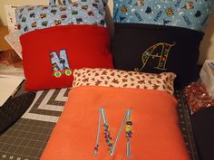 several pillows are sitting on top of a table with scissors and other sewing supplies in front of them