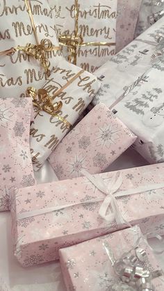 several wrapped presents sitting on top of each other with bows and snowflakes all over them