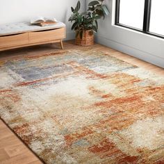 a large rug with an orange, blue and yellow design on it in a living room