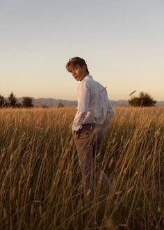 a man standing in the middle of tall grass