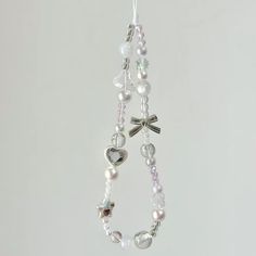 the necklace is decorated with pearls, hearts, and bow brooches on a string