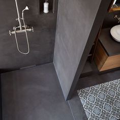 a bathroom with a shower, sink and mirror