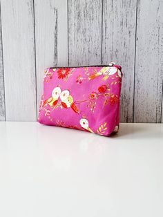 "Cute little zippered pouch. Perfect for loose change, credit card and small set of keys. Or holding small items in your bag that would normally roll around the bottom.  The outer fabric is cute birds on a bright pink background. The lining is pale blue. Made from 100% cotton. Closes with a gold coloured zip with a feather zip pull. Height: 12.7cm (5\") Width: 15.2cm (6\") Depth: 4.5cm (1.75\")" Pink Zipper Pouch For Everyday Use, Pink Zipper Pouch Coin Purse, Pink Zipper Pouch Cosmetic Bag, Pink Pouch Coin Purse With Zipper, Pink Coin Purse With Removable Pouch, Rectangular Pink Coin Purse For Personal Use, Pink Pouch Coin Purse Gift, Pink Pouch Coin Purse As Gift, Bright Pink Background