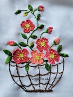 a close up of a piece of cloth with flowers in a wire basket on it