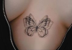 a woman's stomach with a butterfly tattoo on her chest and the wings are black and white