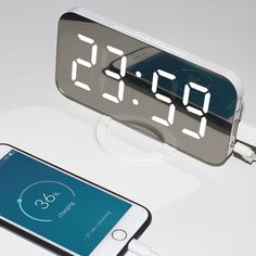 an alarm clock sitting on top of a white table